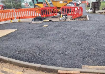 New asphalt path with construction barriers.