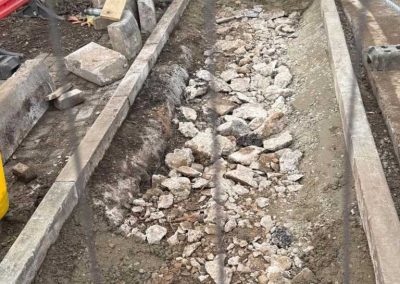 Stone rubble foundation inside concrete curbs.